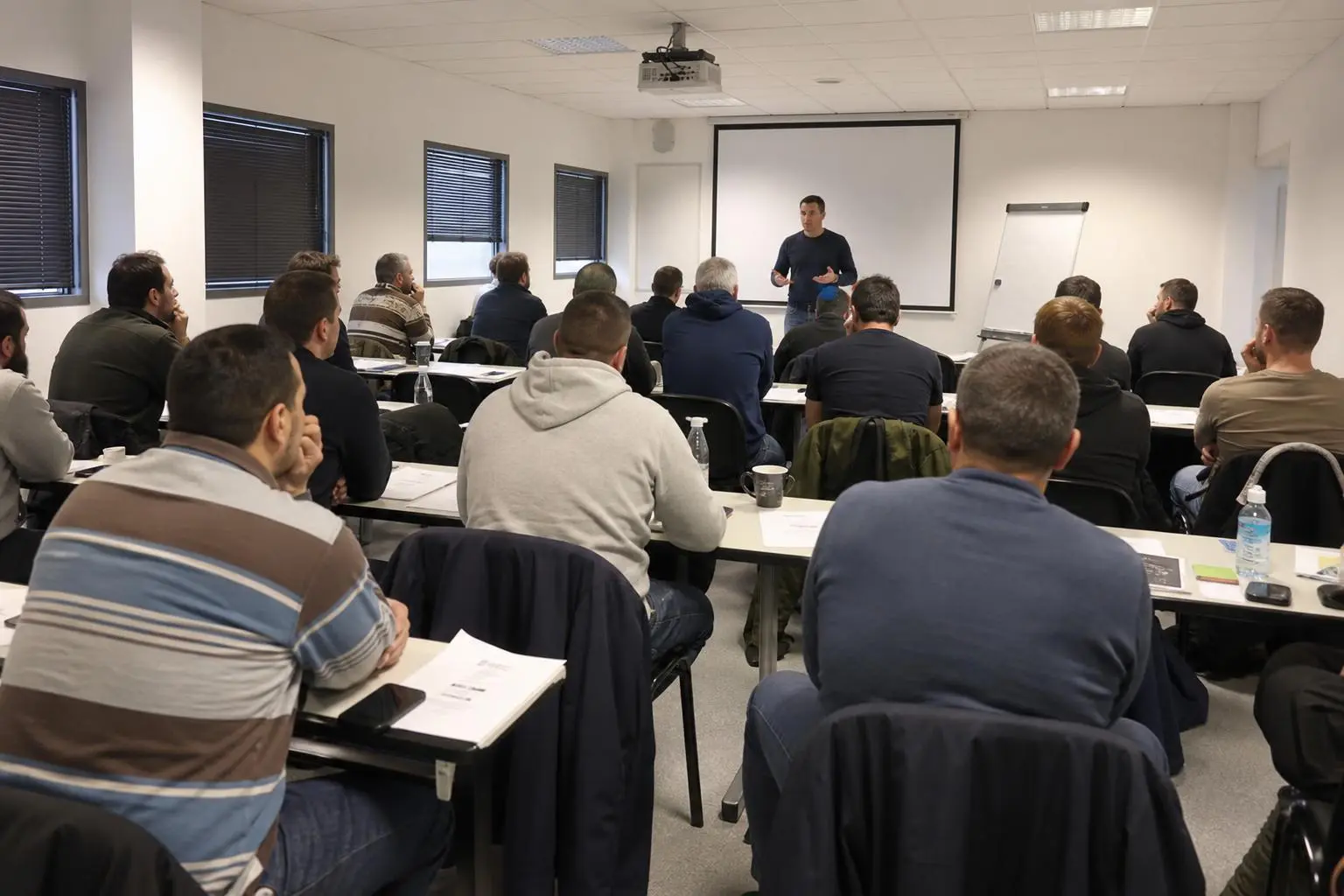 Formation BTP reconversion : salle de formation avec un intervenant devant un groupe d’adultes en atelier pédagogique.